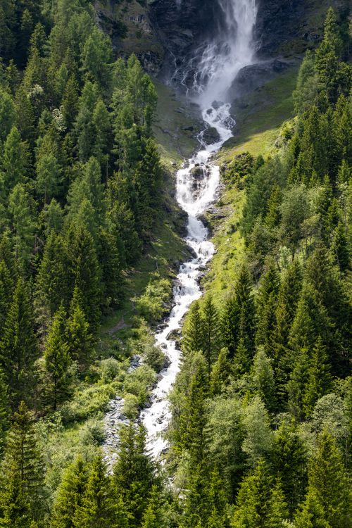 Free Breathtaking waterfall amidst lush greens in Heiligenblut, Austria's Alps. Stock Photo