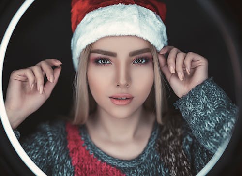 免费 女人穿着圣诞老人的帽子和灰色毛衣 素材图片