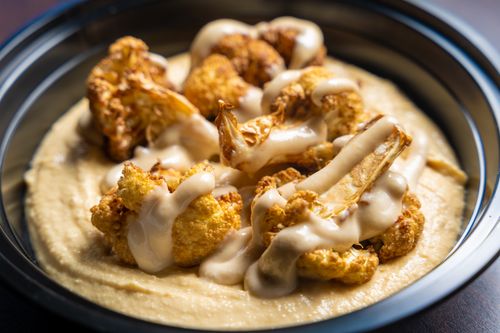 Free Close-up of roasted cauliflower florets drizzled with creamy tahini sauce. Stock Photo