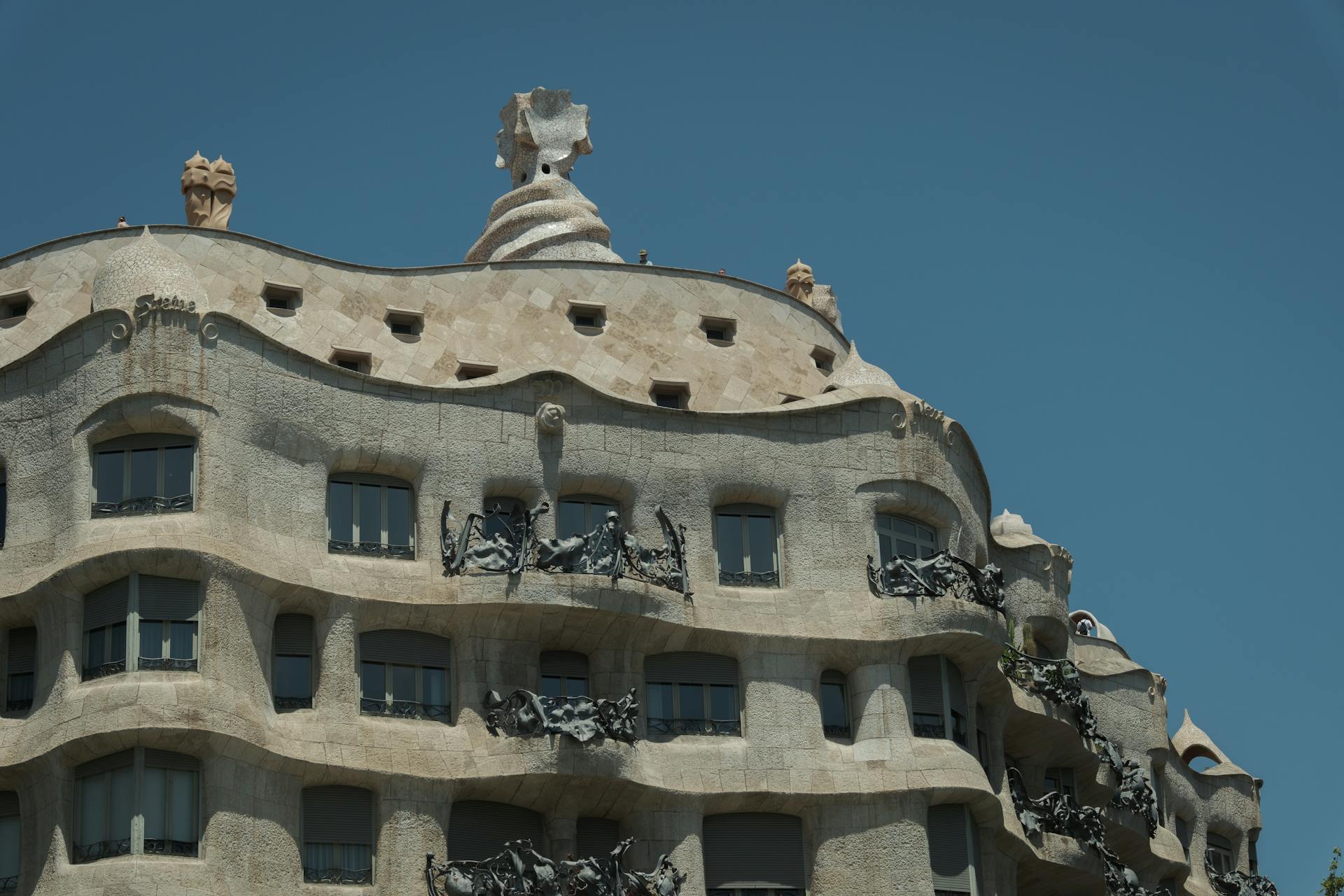 Ornate Casa Milà in Barcelona showcasing Gaudí's unique architectural style against a blue sky.