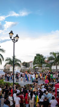 Vibrant pride parade in Panama City with colorful flags and diverse crowd.