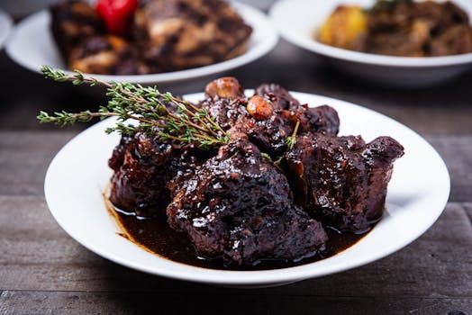 Close-up of tender braised oxtail with herbs, perfect for a gourmet dinner.