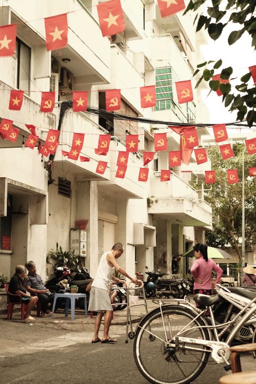 Free Urban street scene with people and flags creating a vibrant community atmosphere. Stock Photo