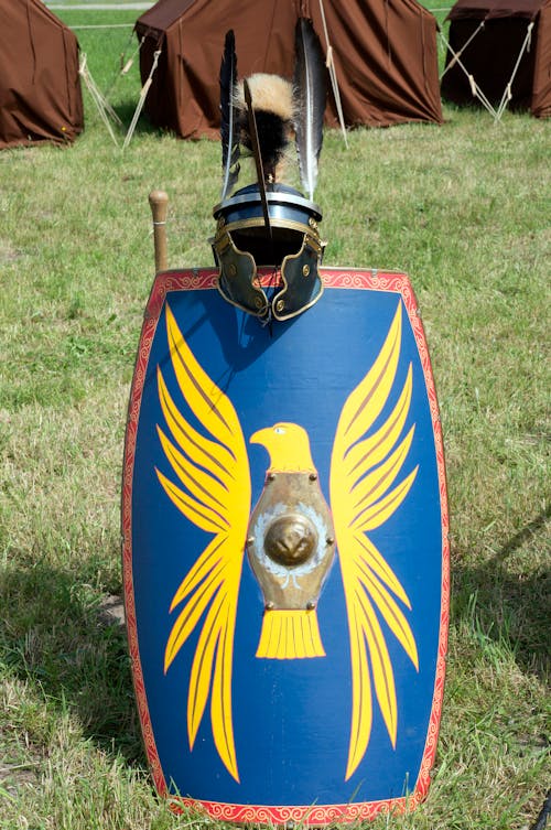 Metal helmet and shield on green