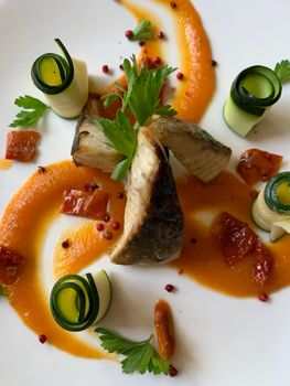 Exquisite salmon dish artfully presented with zucchini and vibrant sauce, perfect for gourmet dining.