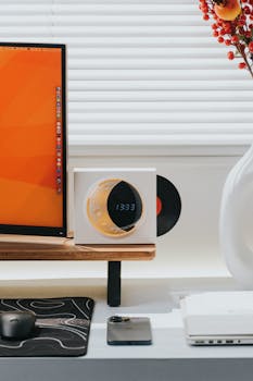 Contemporary home office setup featuring a computer, clock, and vinyl record display.