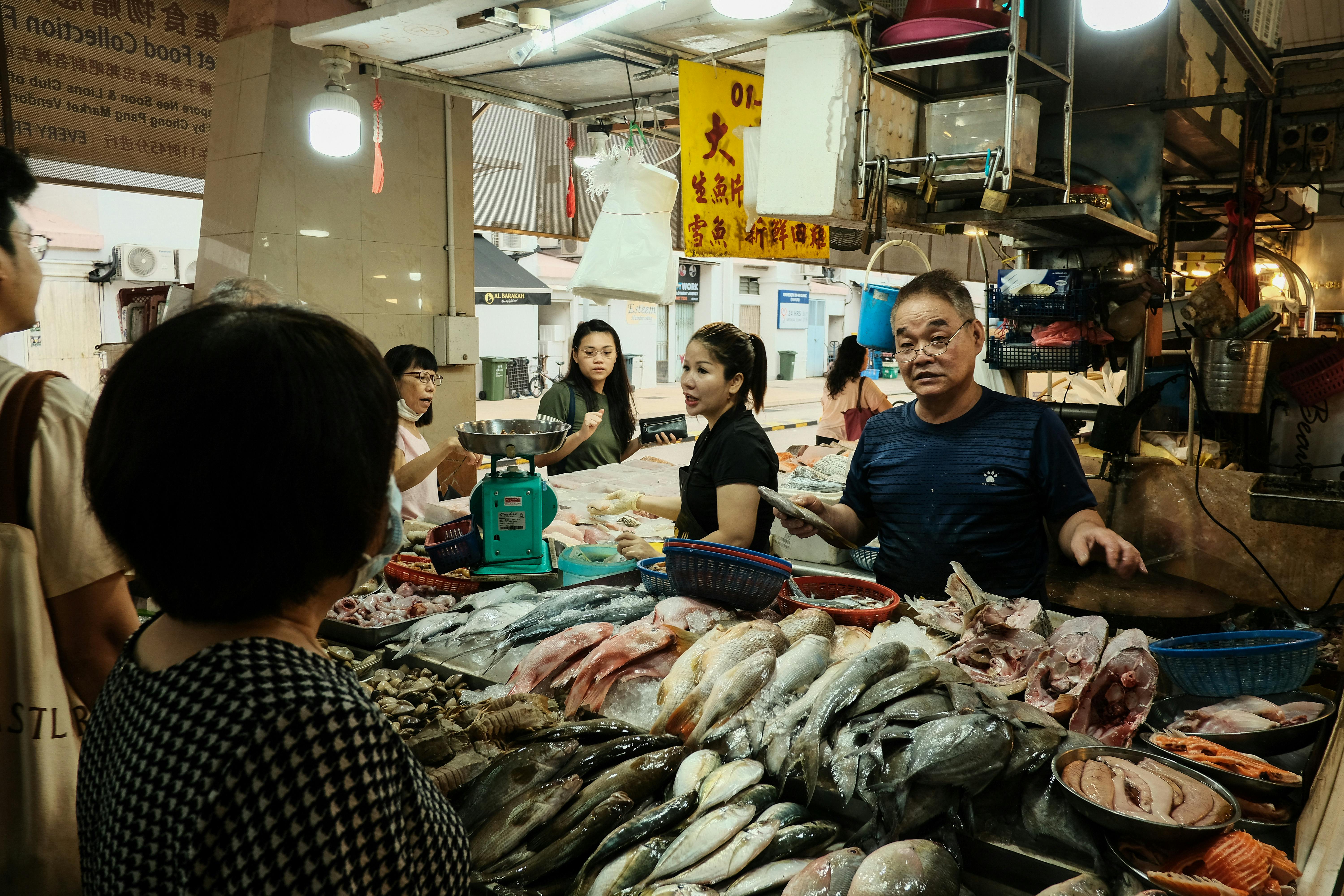 A man standing in front of a fish market · Free Stock Photo