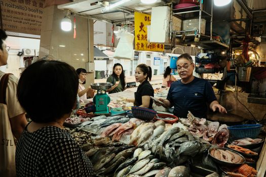 A man standing in front of a fish market