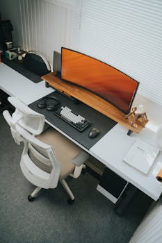 Contemporary office setup featuring a curved monitor and ergonomic chair.
