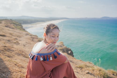 Woman Sitting By The Cliff