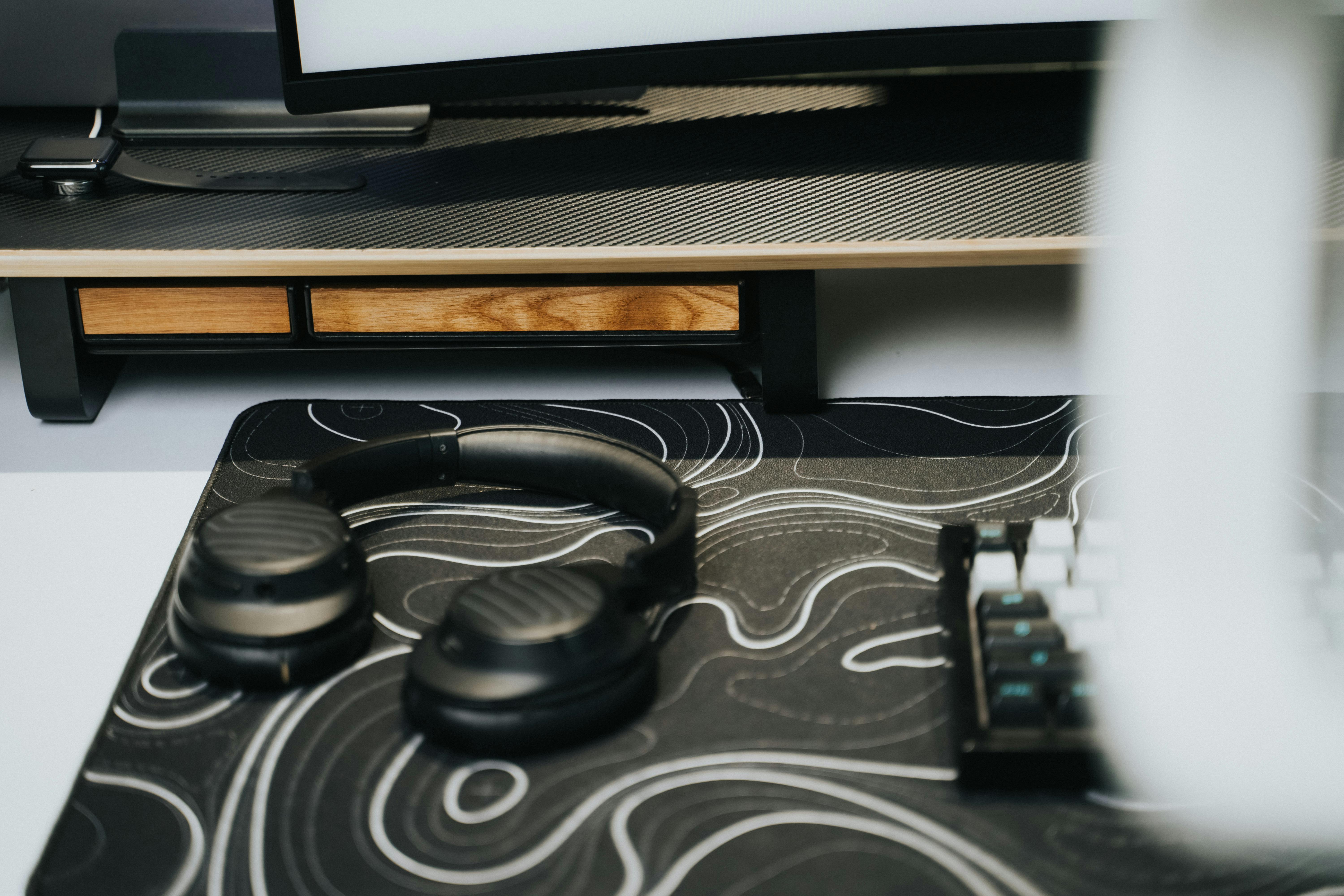 A modern workstation featuring headphones and keyboard with sleek design elements.