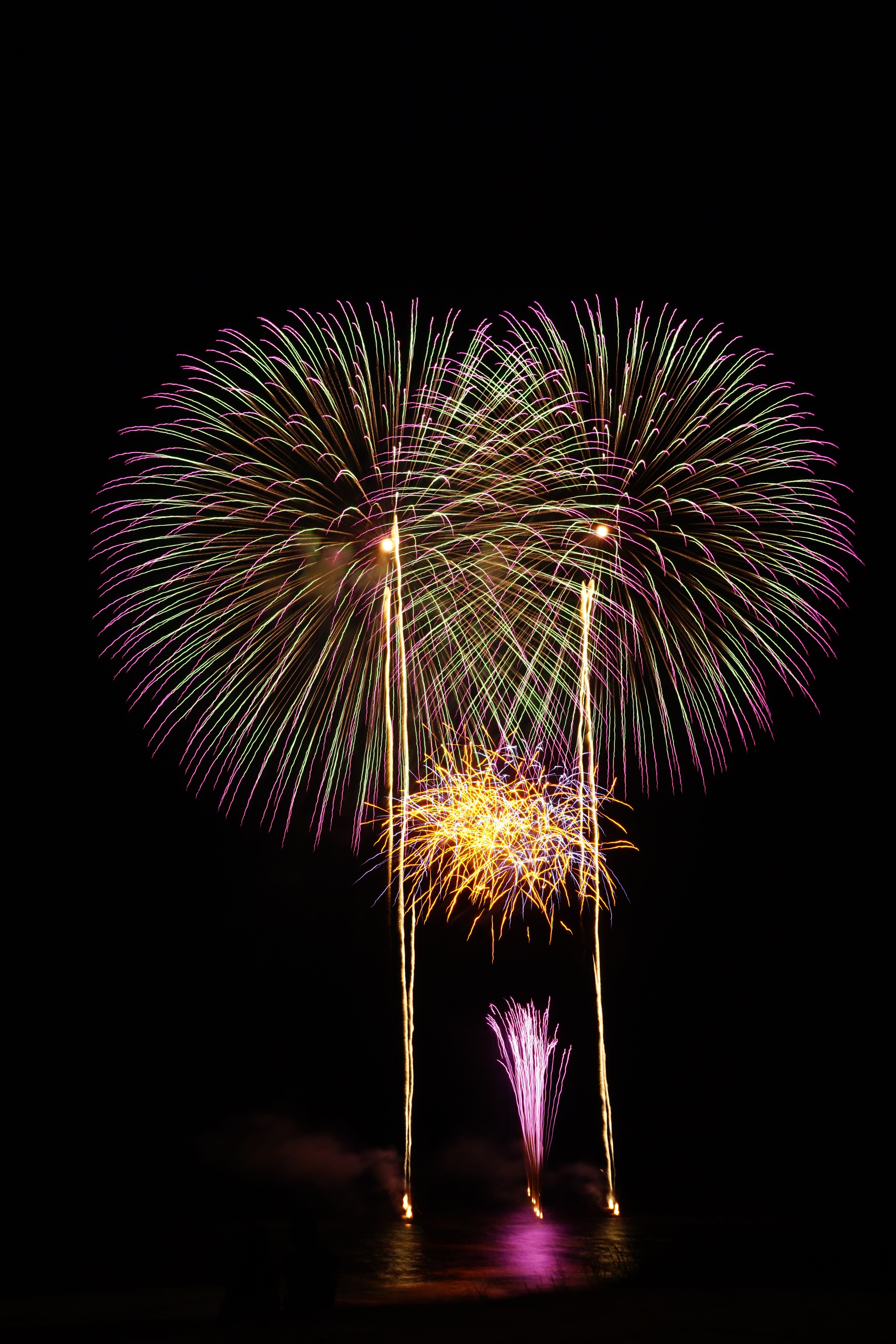 An impressive display of colorful fireworks lighting up the night sky over a body of water.