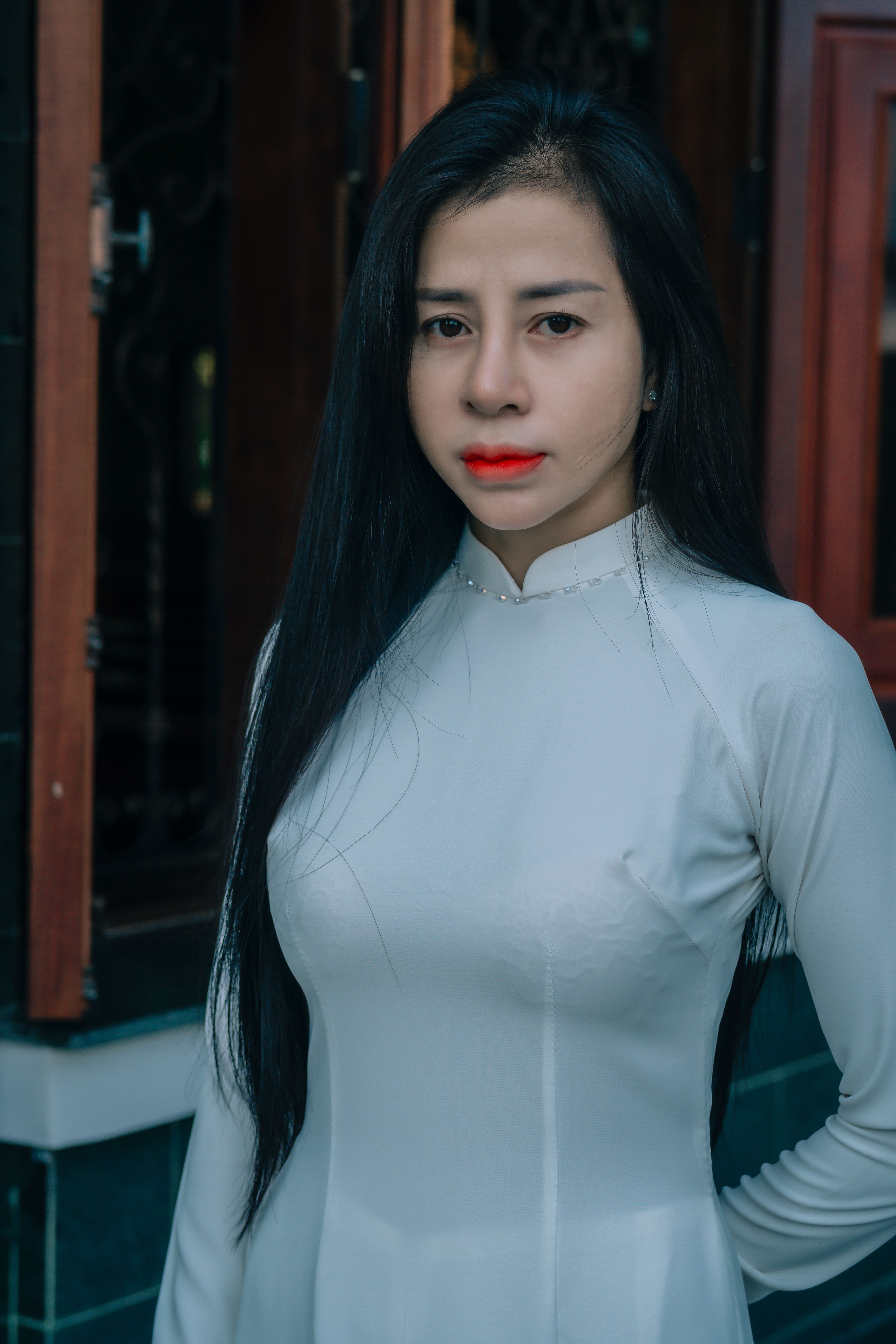 Portrait of an elegant woman in a traditional dress standing outdoors.