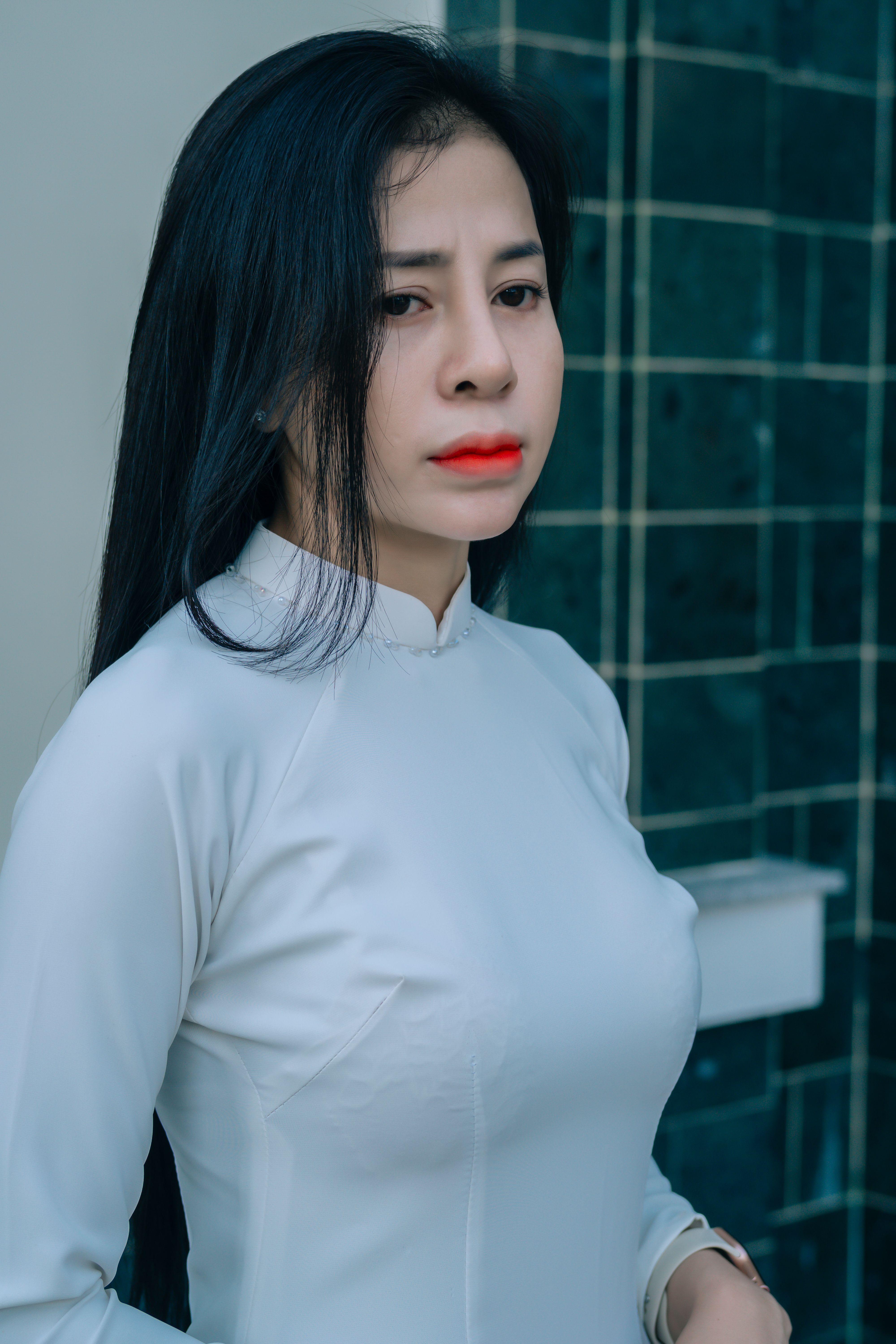 Portrait of a young woman in elegant white traditional attire with a serene expression.