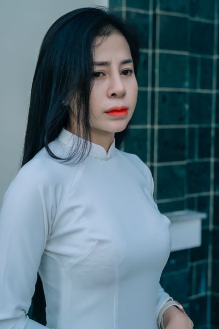 Portrait of a young woman in elegant white traditional attire with a serene expression.