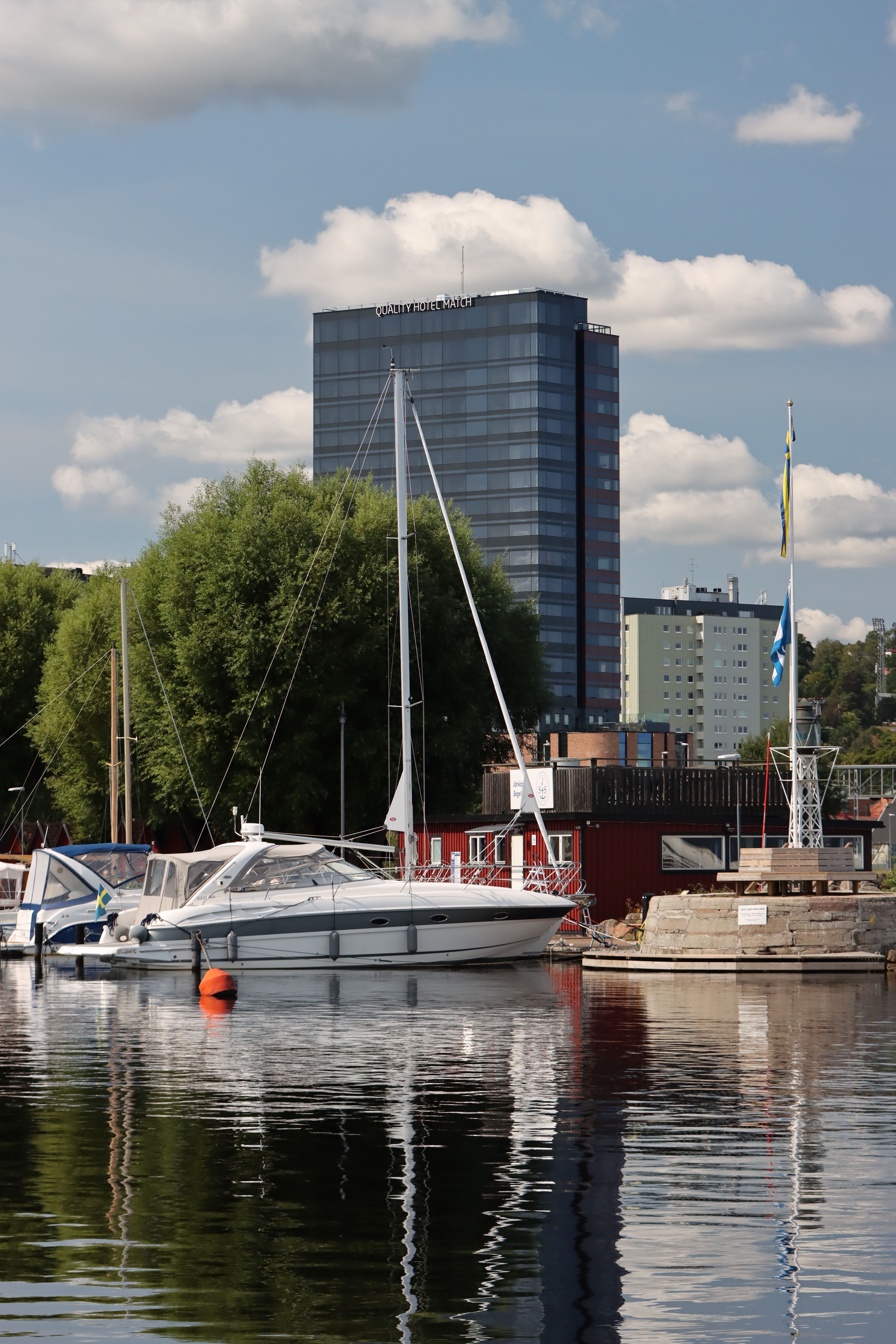 Captivating view of Jönköping marina with boats and waterfront buildings under a sunny sky.