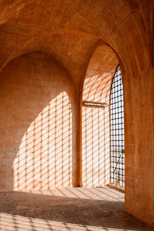 Free Interior of a stone building showcasing gothic arches and lattice shadows. Stock Photo