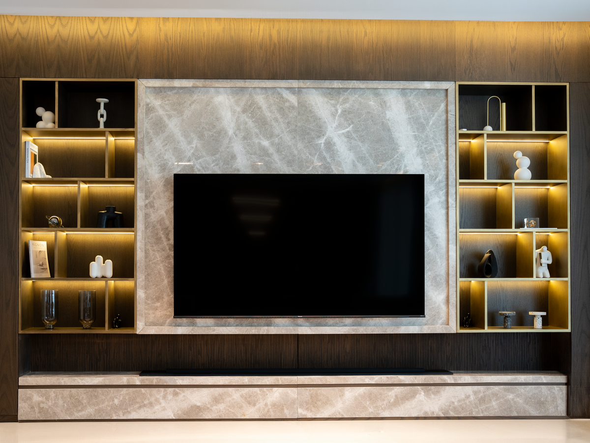 Painted media wall with a recessed TV, inset electric fire and shelves in a UK living room