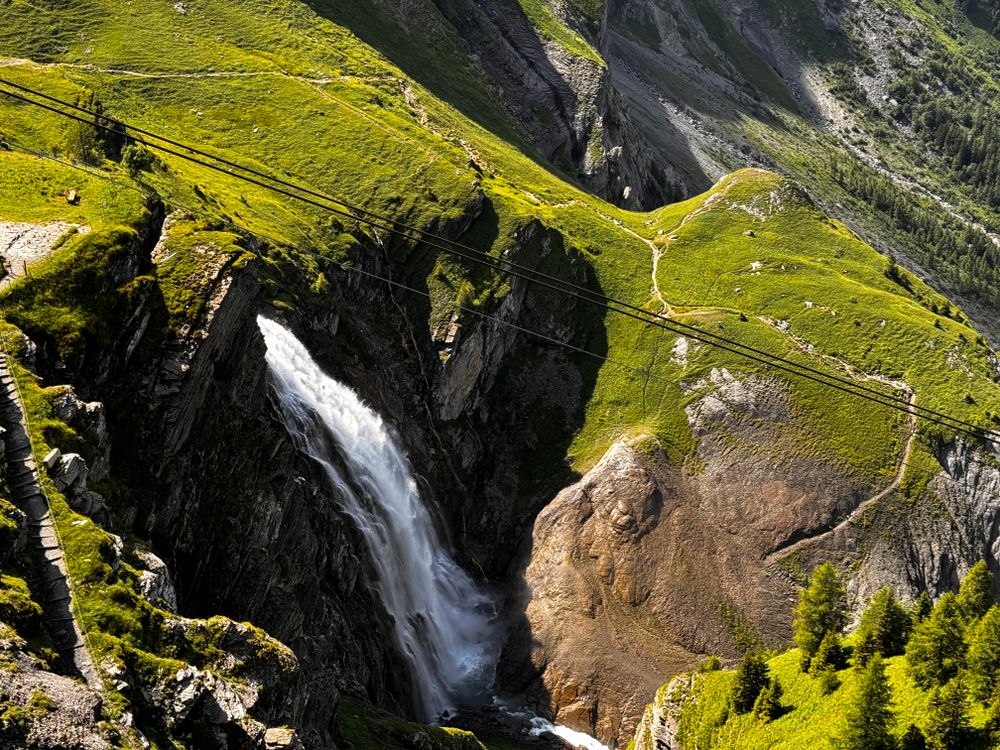 A waterfall is flowing down a mountain side · Free Stock Photo
