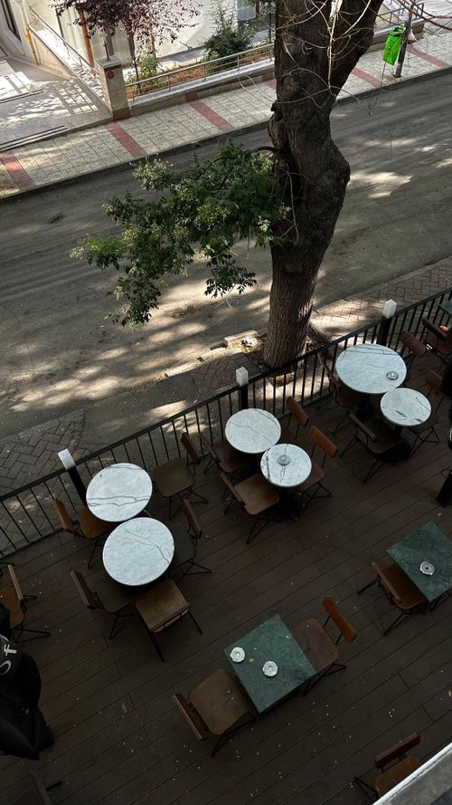 Free Aerial view of empty cafe tables on a quiet urban street. Stock Photo