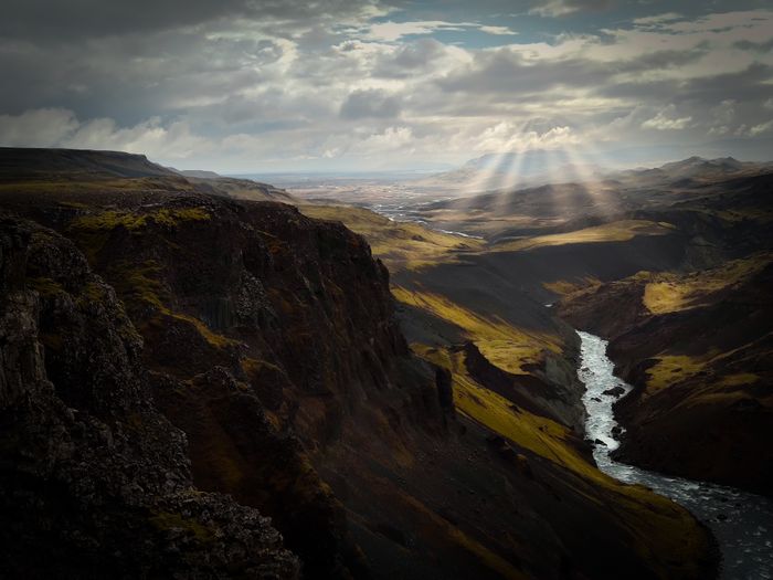 Majestic mountainous landscape with a river winding through a sunlit gorge, showcasing nat, by David Zherdenovsky on Pexels
