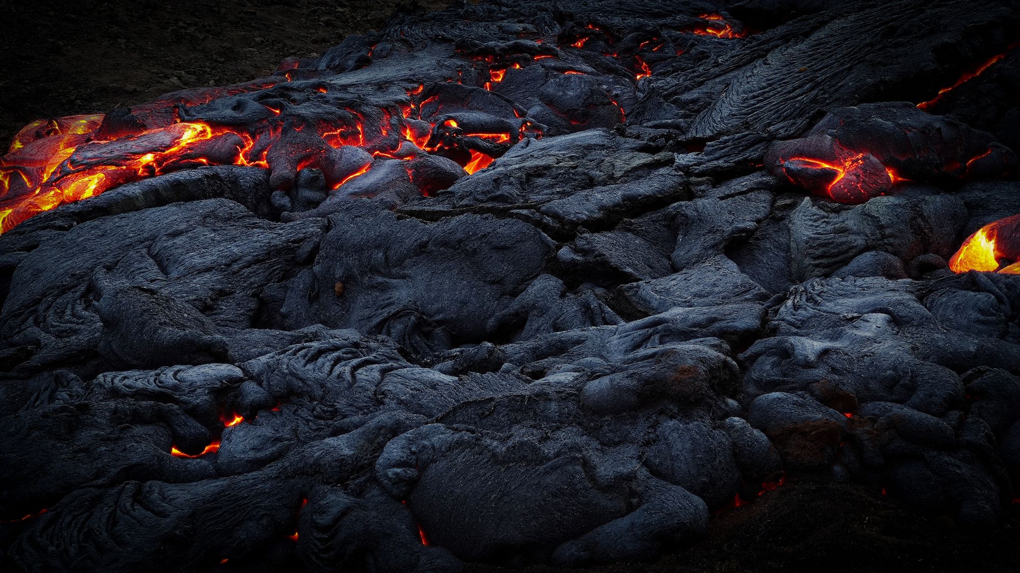Fisura volcánica en Islandia con lava incandescente saliendo del suelo durante la noche