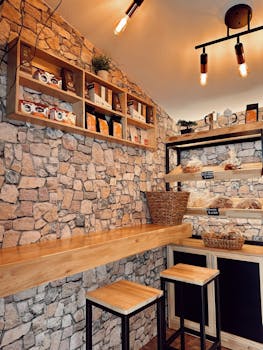 Warm interior of a rustic cafe featuring stone walls and wooden furniture.