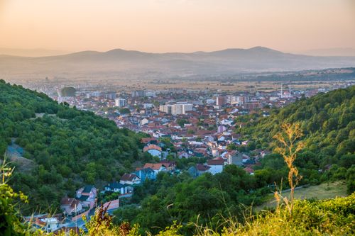 Free Scenic view of the town of Preševo surrounded by lush hills in Serbia at sunset. Stock Photo
