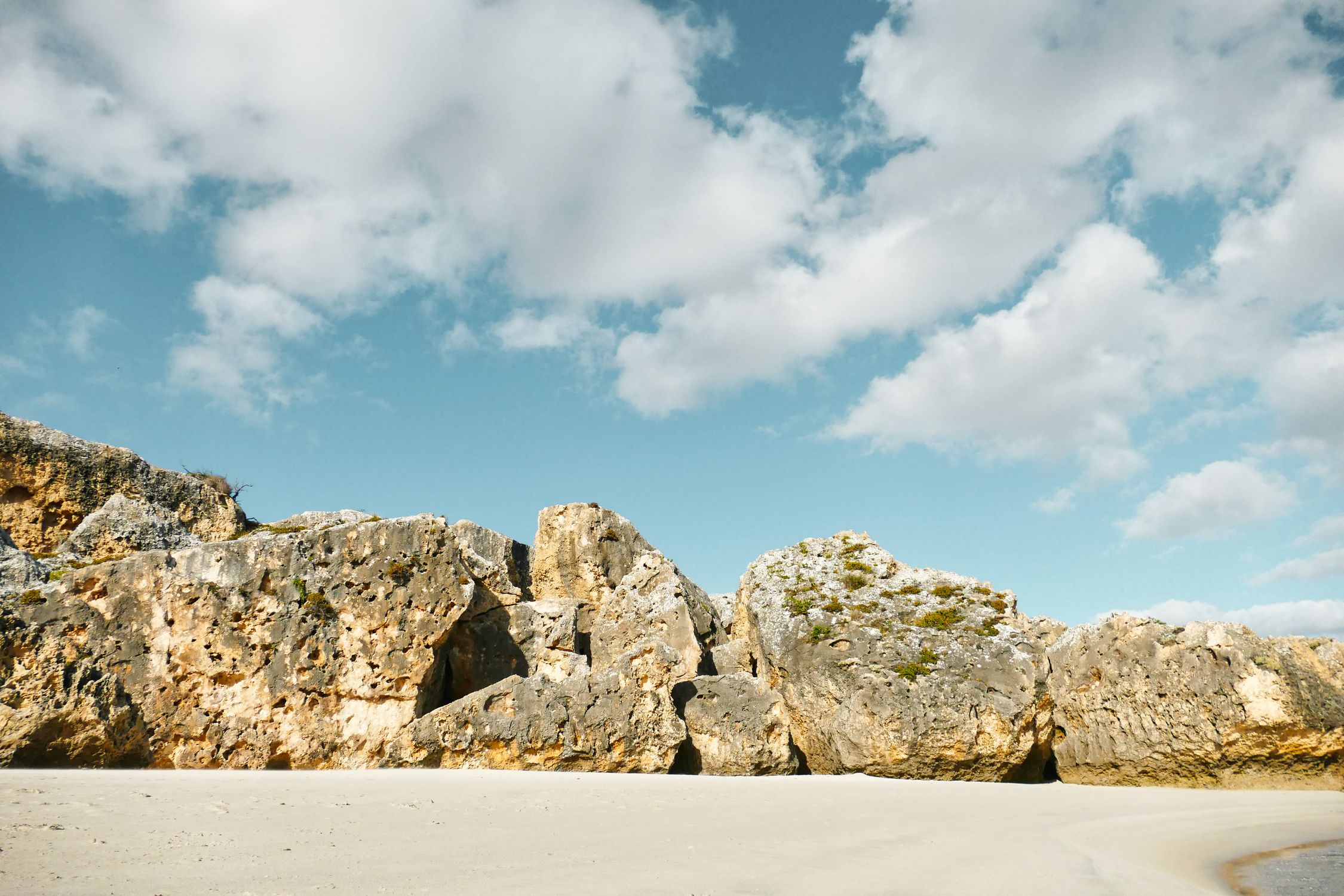 Peaceful Beachscape: Sunlit Cliffs and Pristine Sand · Free Stock Photo