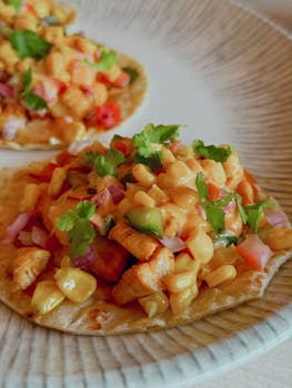 Close-up of colorful Mexican tacos topped with fresh vegetables and cheese.
