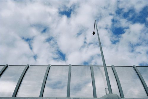 Free Contemporary architectural design of a glass structure under a cloudy sky in Poznań, Poland. Stock Photo