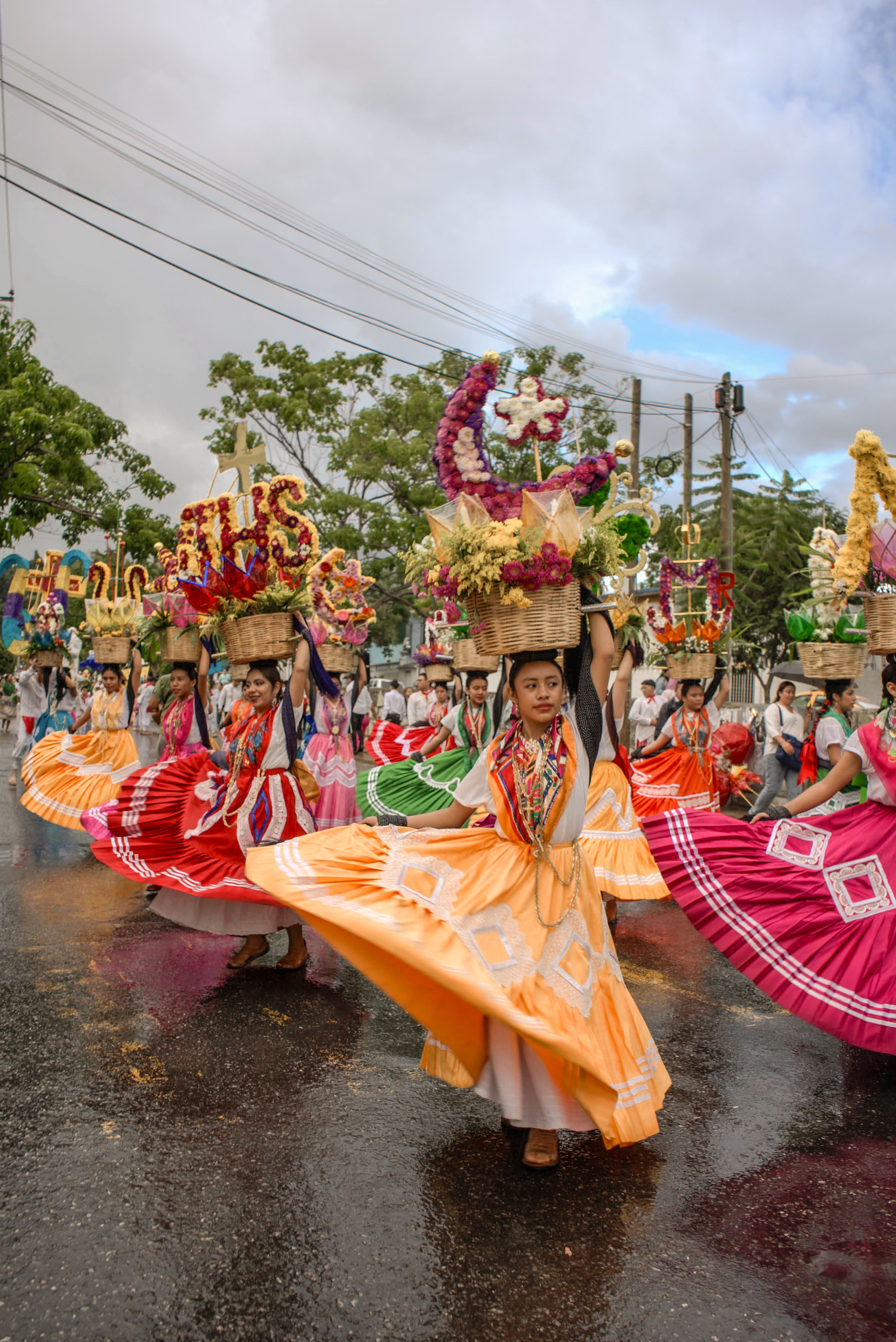A group of women dressed in colorful costumes are walking down the ...