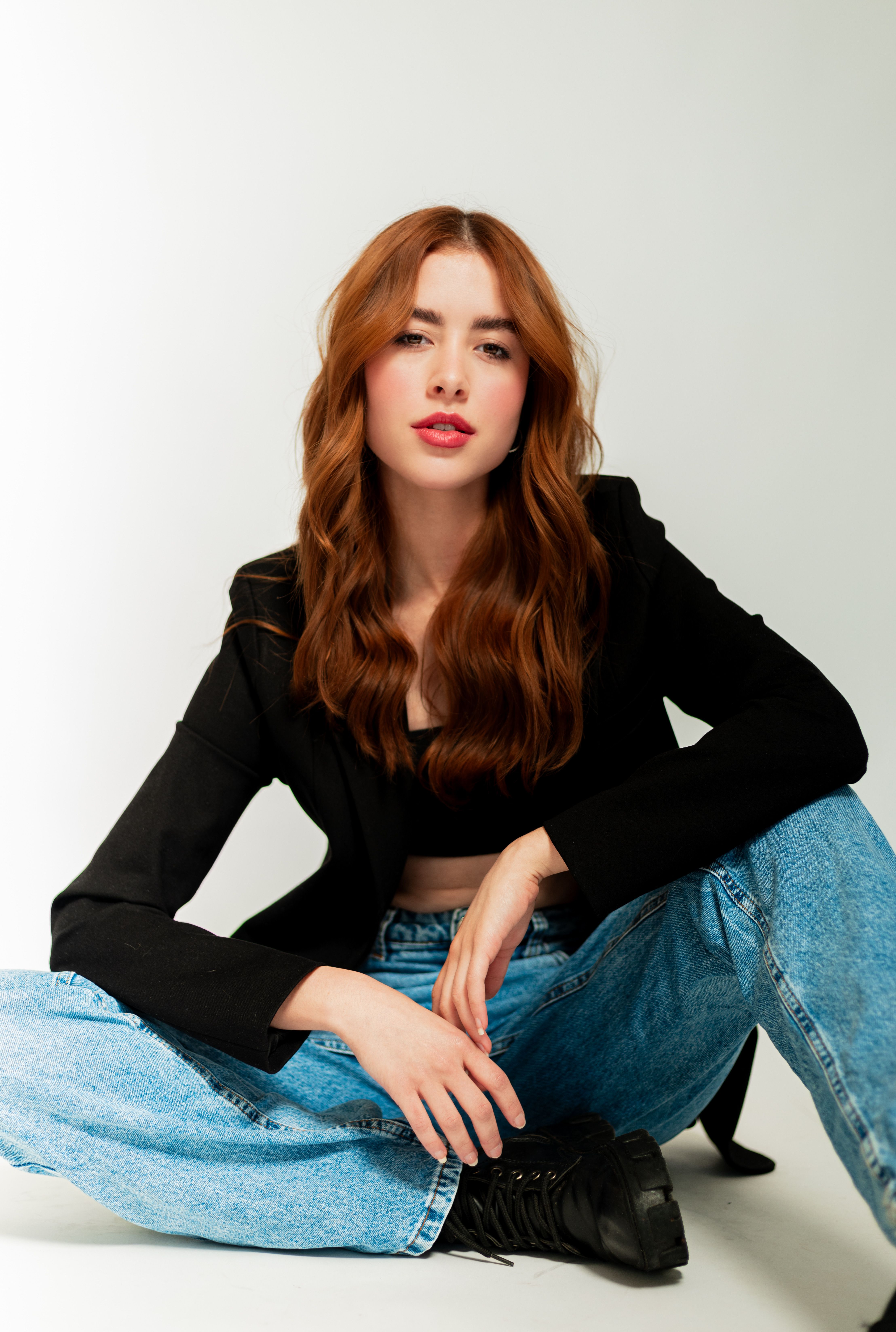 A woman with red hair sitting on the floor · Free Stock Photo