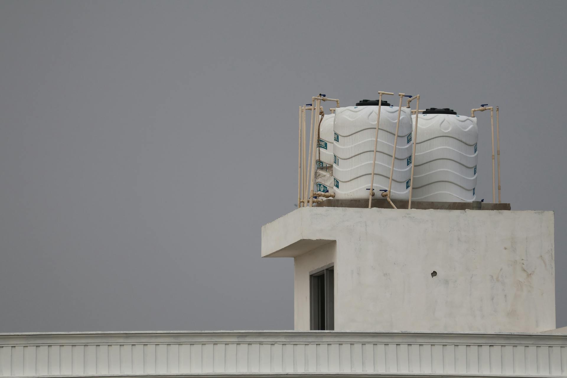 A white roof with two water tanks on top