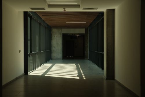 Free A minimalist hallway with concrete elements, showcasing natural light and shadows, emphasizing modern architecture. Stock Photo