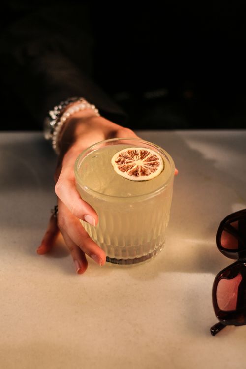 Free Stylish woman enjoying a refreshing lemonade at a cafe. Stock Photo