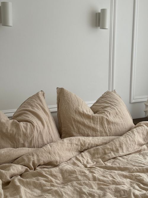 Free A bed with two pillows and a light brown duvet Stock Photo