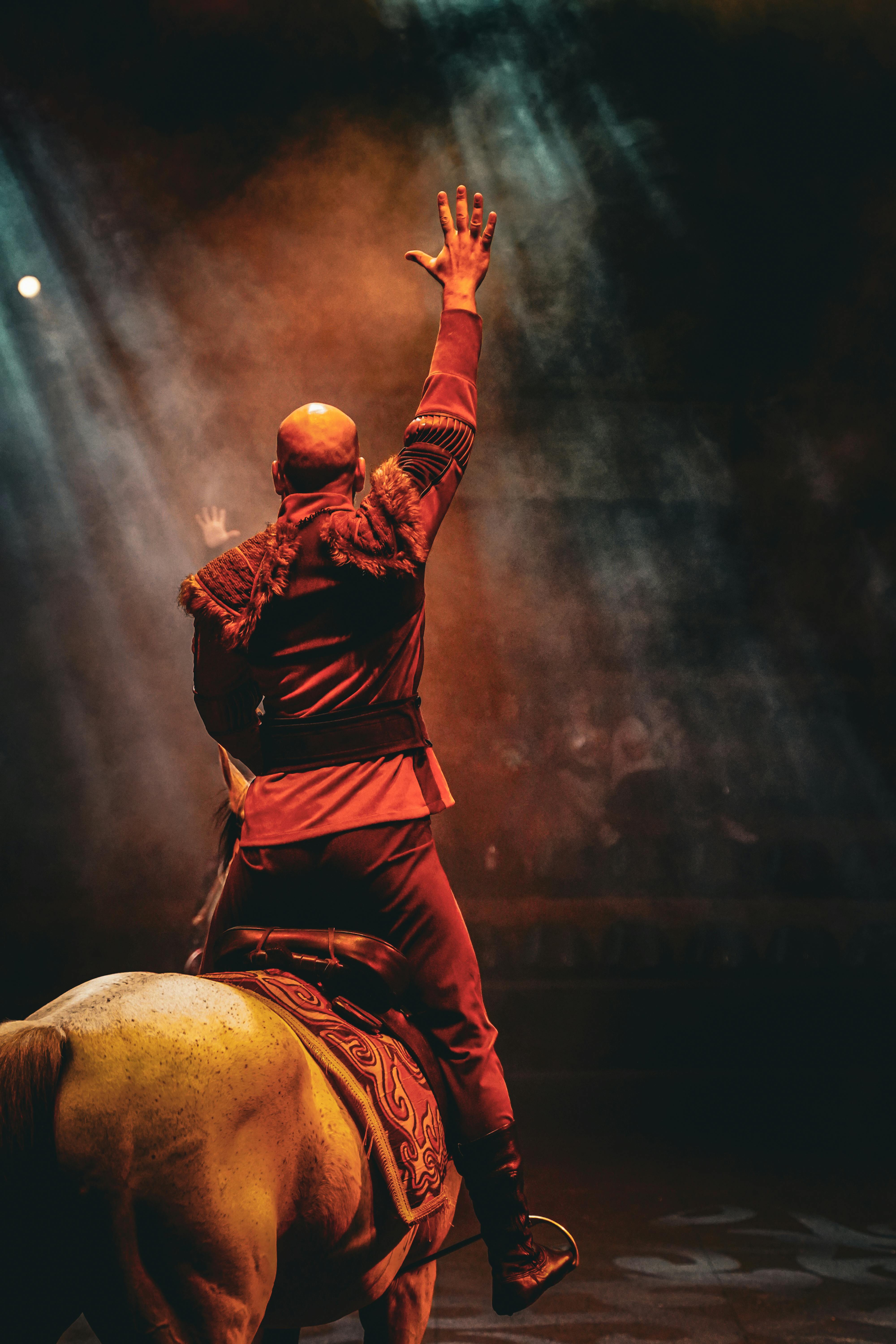Free A captivating scene of a horseback performer in a dramatic spotlight at a night event. Stock Photo
