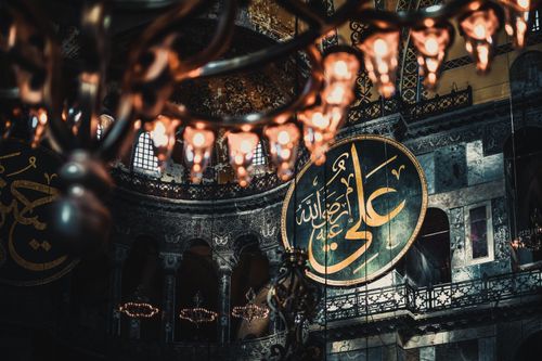 Free Chandelier lights and intricate Islamic calligraphy inside Hagia Sophia, Istanbul. Stock Photo