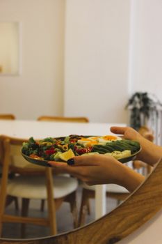 A colorful salad in a modern dining room, highlighting fresh ingredients and minimalist decor.