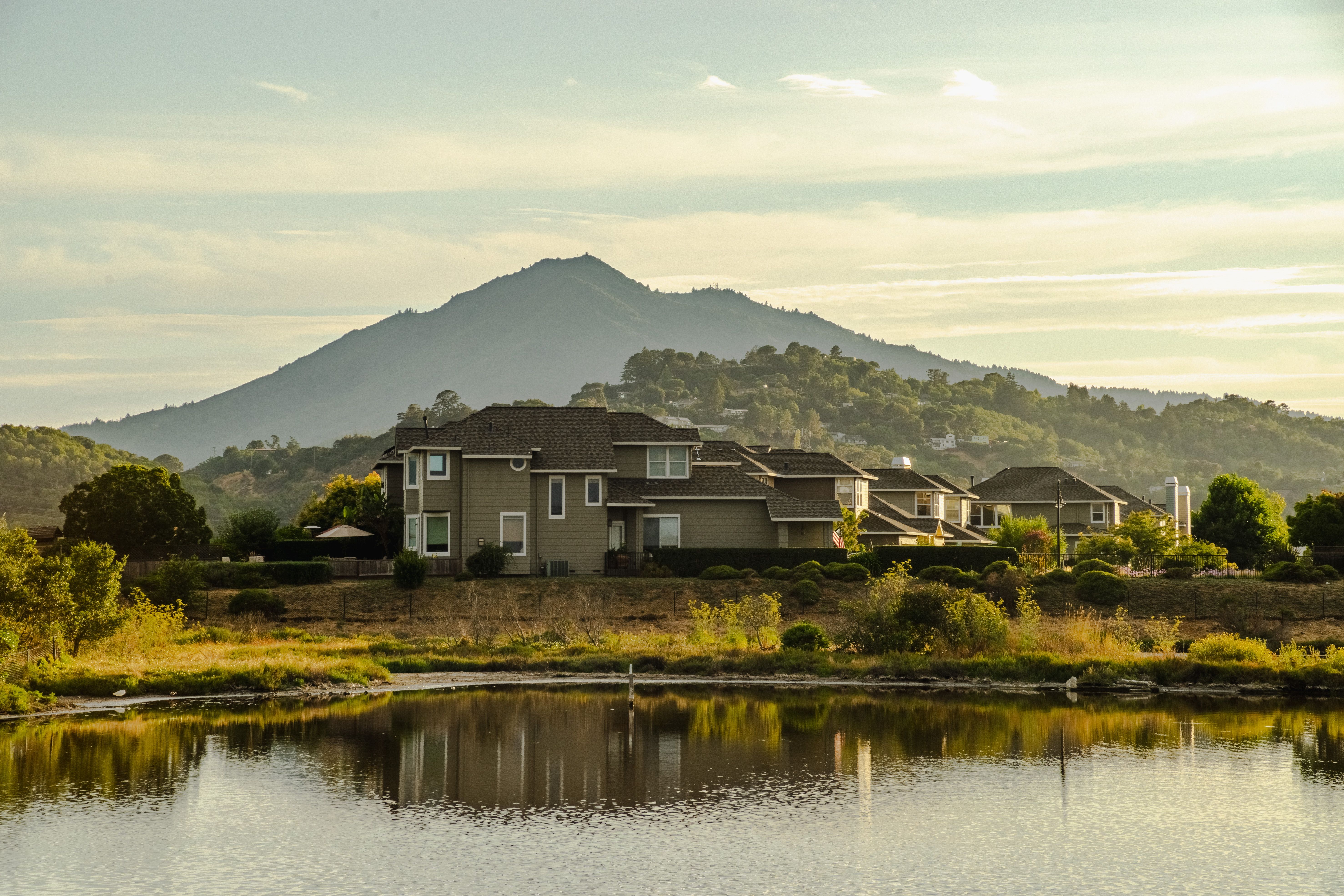 A lake with houses and mountains in the background · Free Stock Photo