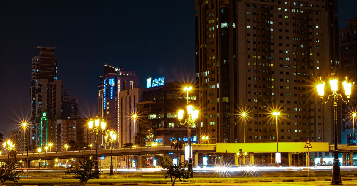 Stunning night view of Sharjah cityscape with modern skyscrapers and lit streets.
