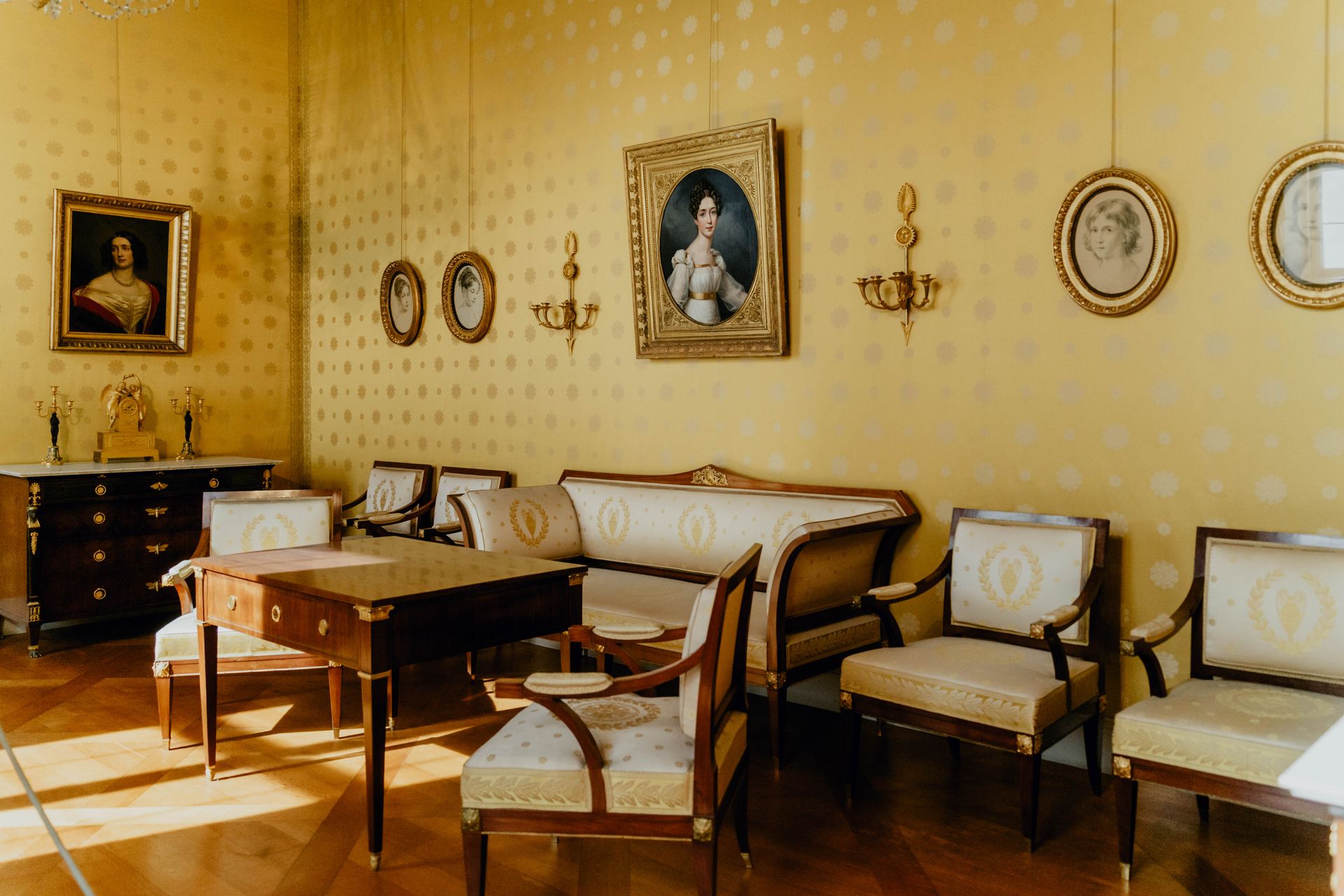 A luxurious room in München featuring vintage furniture and classic portrait paintings.