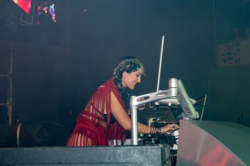 Free Energetic DJ performing live on stage at a vibrant music festival, engaging the crowd with beats. Stock Photo