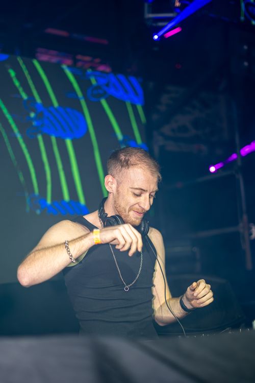 Free Energetic DJ on stage, captivating the crowd at a vibrant music festival. Stock Photo