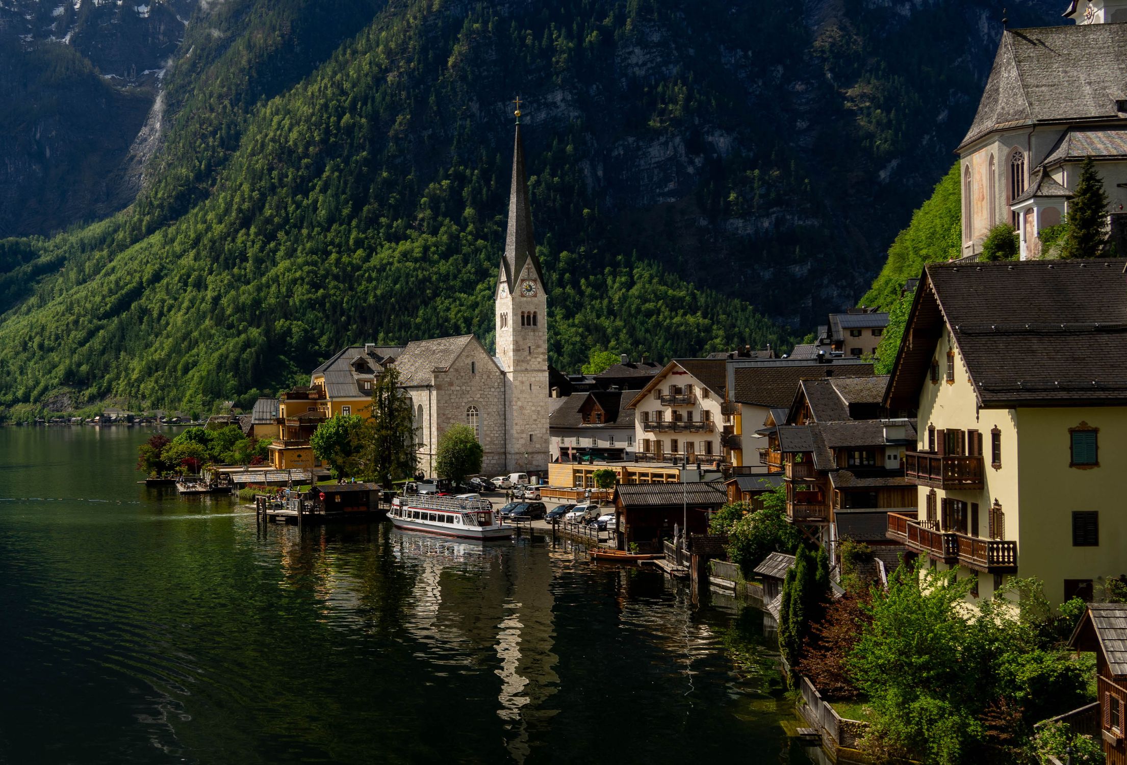 Charming view of Hallstatt with its iconic church by the lake against a backdrop of mountains.