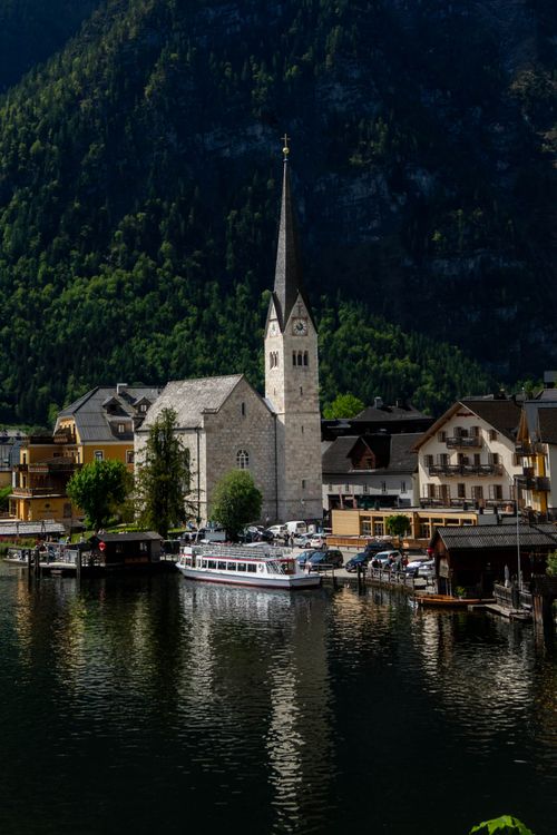 Free Picturesque view of Hallstatt village in Austria with a church reflected on the water. Stock Photo