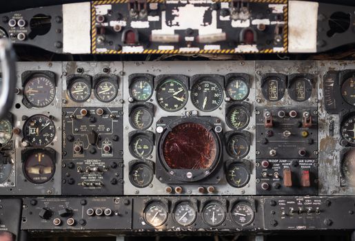 Close-up of a vintage aircraft cockpit control panel showcasing various dials and gauges.