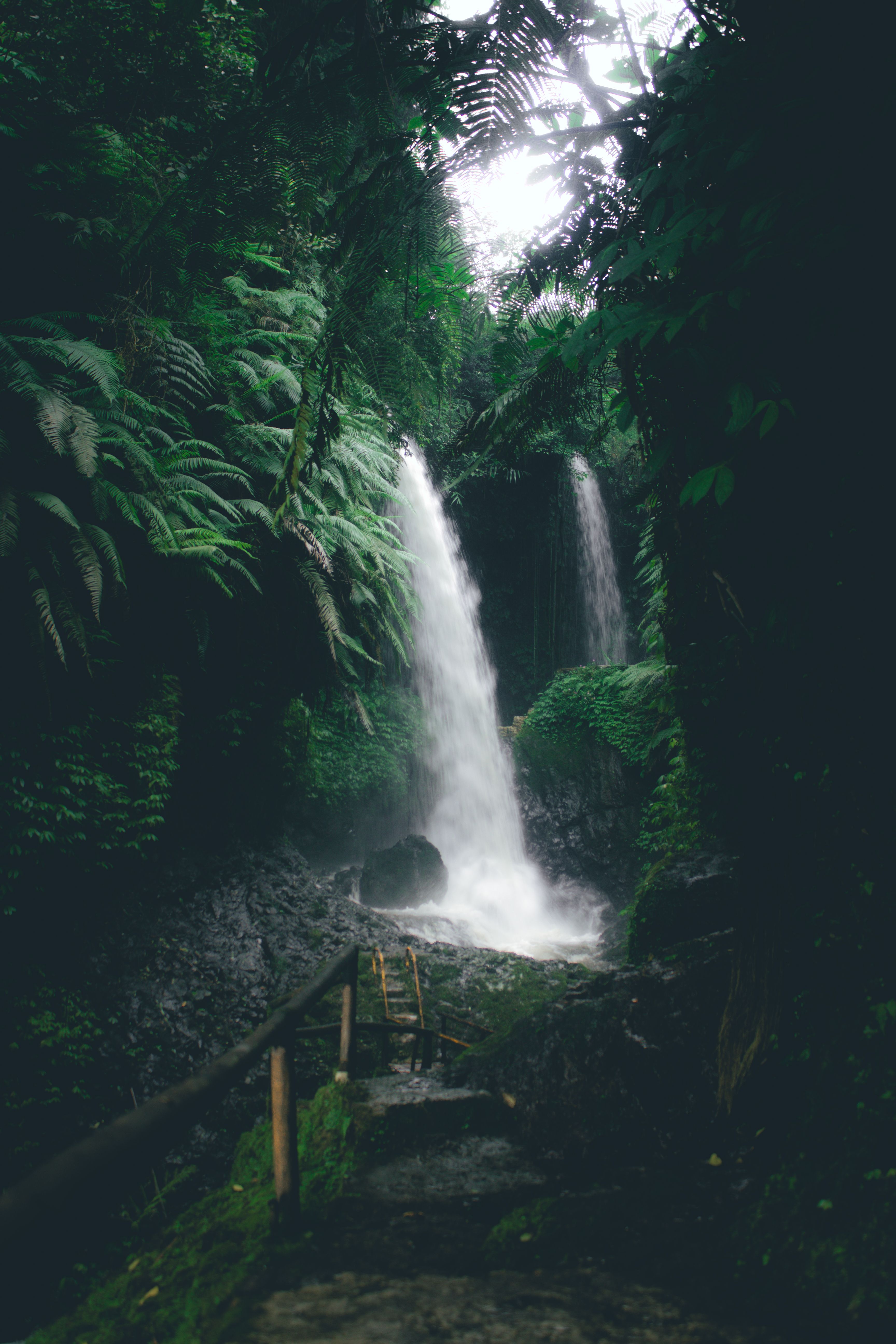 A tranquil waterfall cascades through lush greenery in Bandung, Indonesia. Perfect for nature and travel enthusiasts.