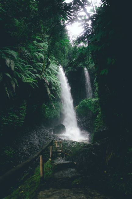A tranquil waterfall cascades through lush greenery in Bandung, Indonesia. Perfect for nature and travel enthusiasts.